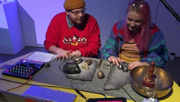 two individuals sat at desk with rocks and stones