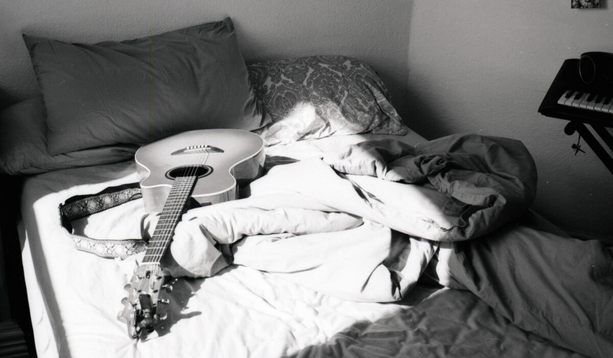 a black and white photogtaph of a sun lit bedroom