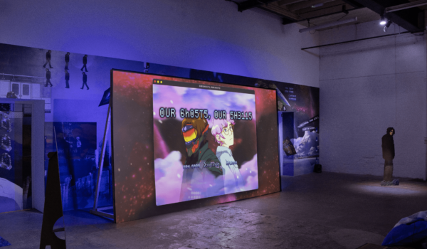 A film installation in a gallery setting. The lighting and colours are blue and purple.