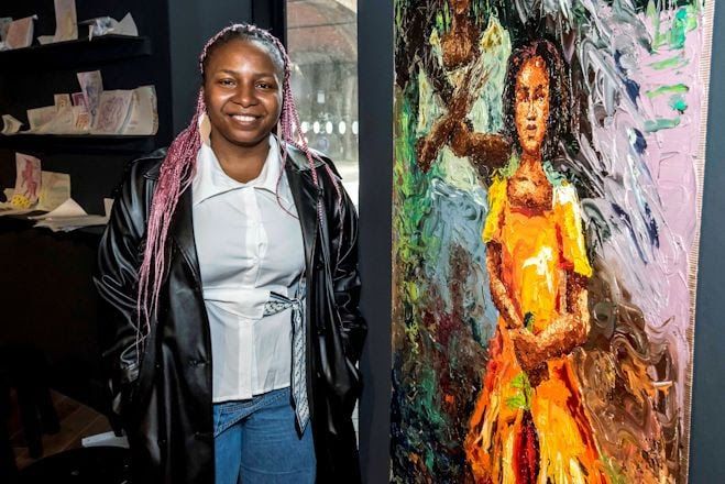 A woman stood next to a thick, impasto oil painting