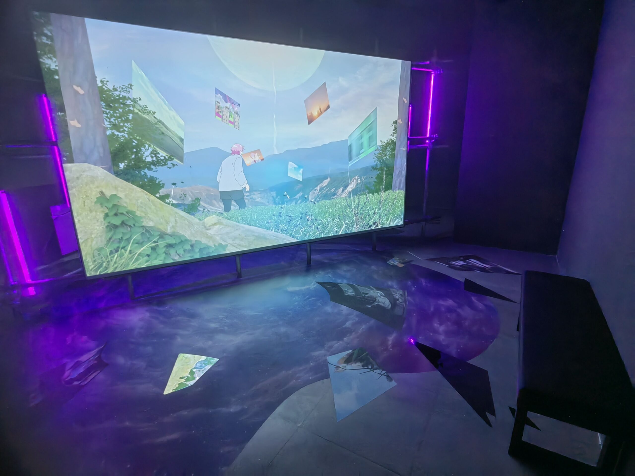 a large room with purple lighting. A bright screen fills and lights the room with animted artwork.