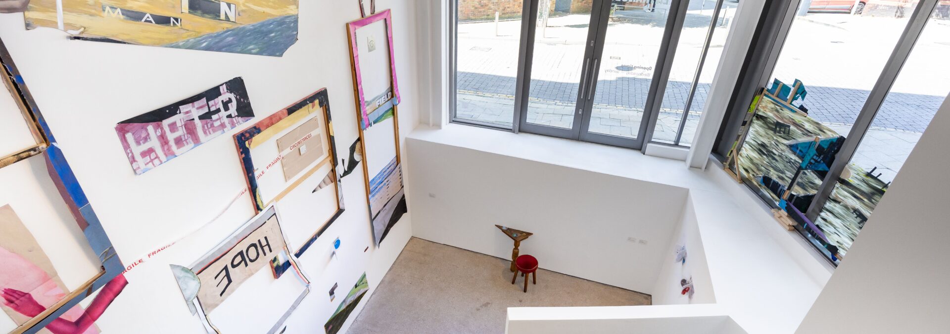 top-down view of the Interior of Castlefield Gallery, white walls and concrete floors. featuring collage artwork by Joe O'Rourke.