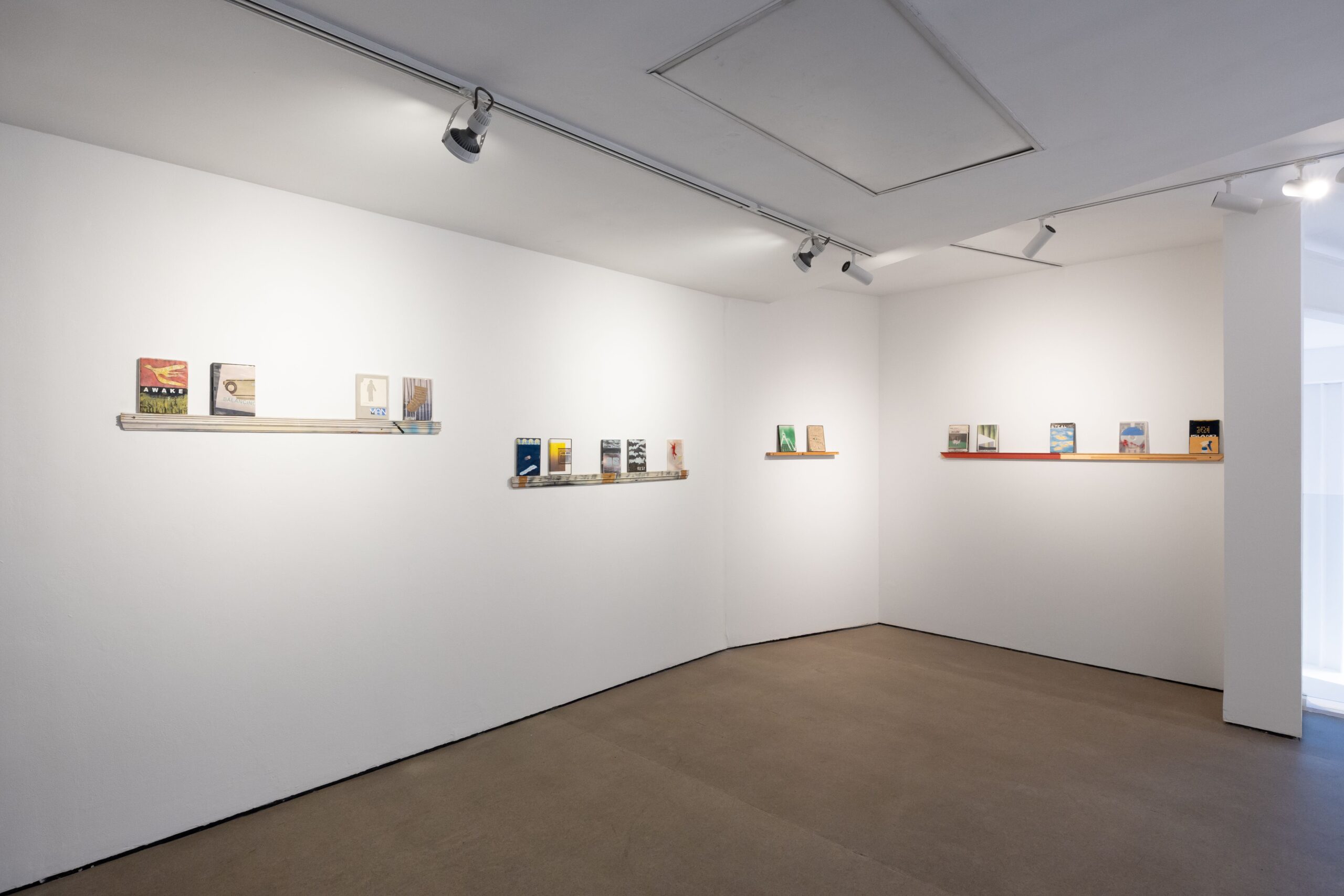 Interior of Castlefield Gallery, white walls and concrete floors. featuring art on dvd cases by Joe O'Rourke.