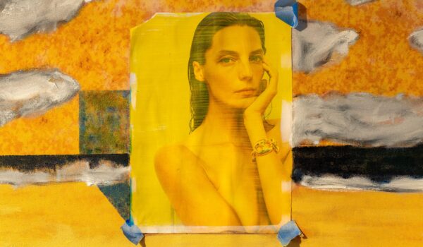 A yellow collage image of a woman from an advertisement over an abstract painted surface.