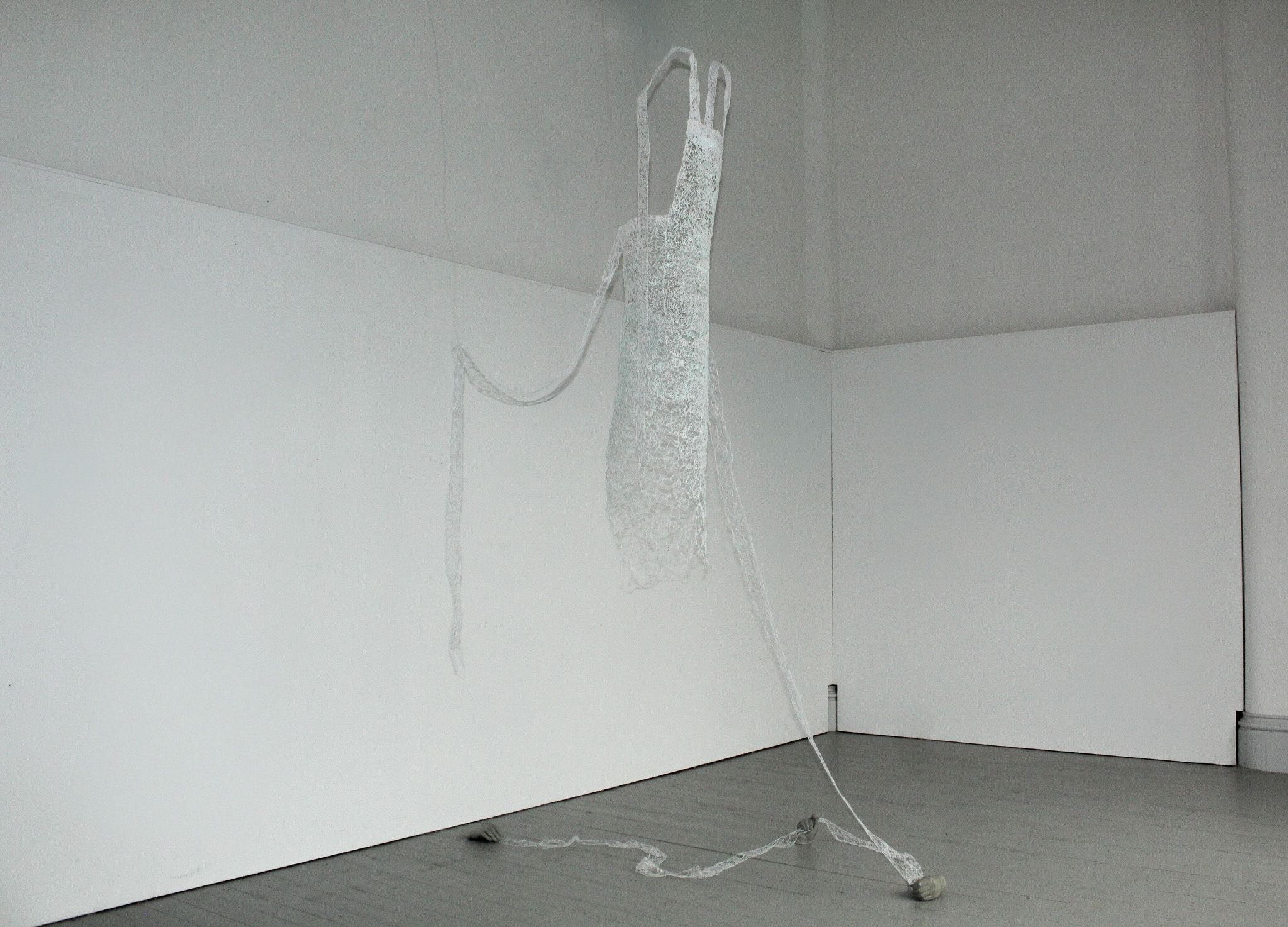 a white room with a white airy sculpture hanging from the ceiling.