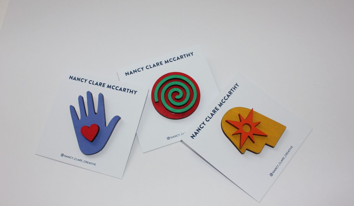 Three wooden brooches laid out against a white background.