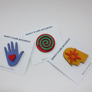 Three wooden brooches laid out against a white background.