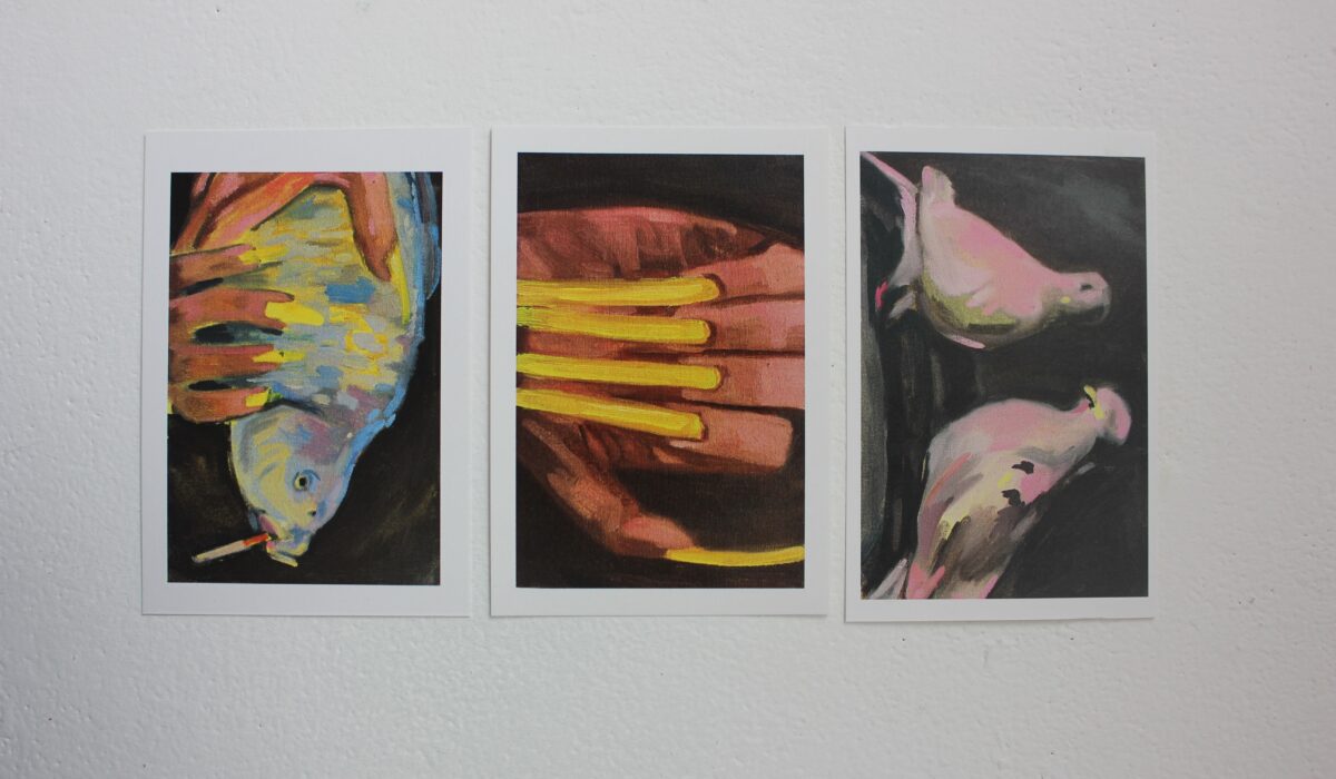 Three postcards of a fish, acrylic nails, and two pigeons against a grey background.